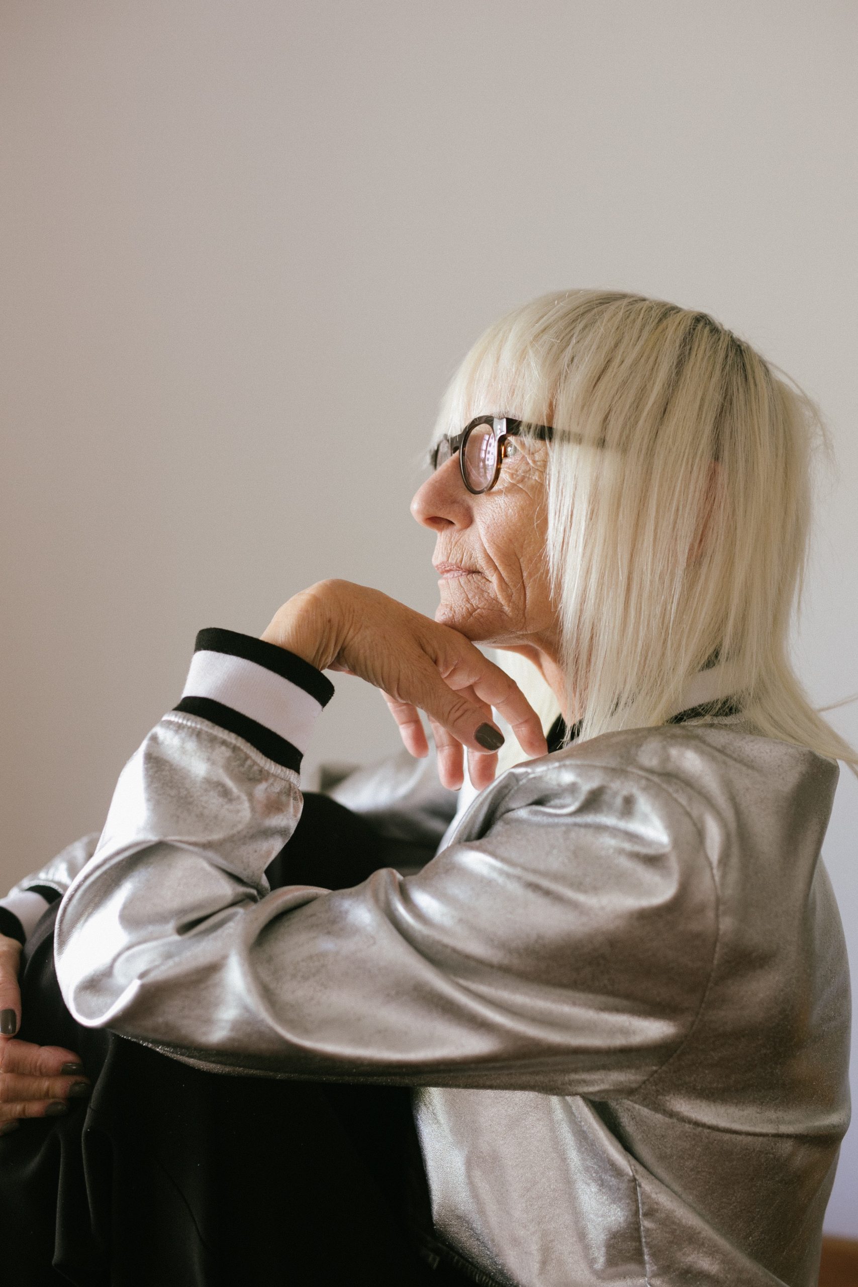 pensive-elderly-woman-in-eyeglasses-and-trendy-bomber-3867213